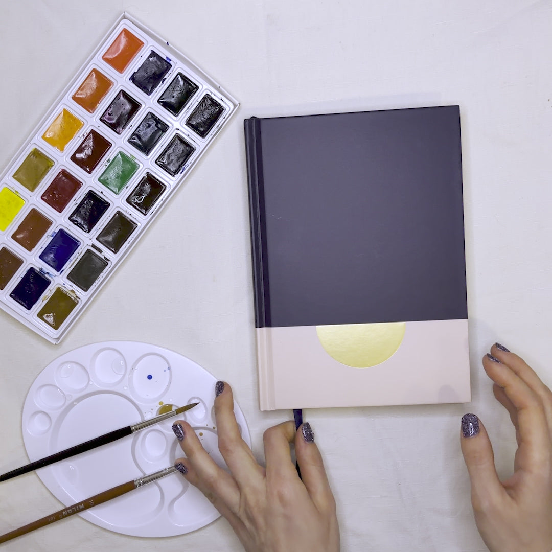 Video-Präsentation des Lavianne Sunrise Marine Aquarellbuchs: Elegantes Umblättern der 230 g/m² starken Seiten und Fokus auf das tiefblaue Einband-Design mit Goldprägung.